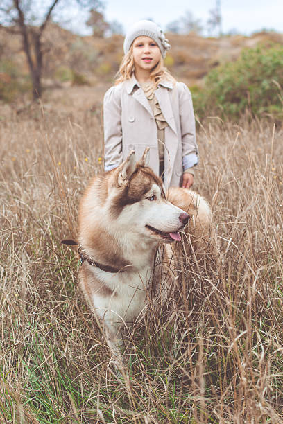 istock Girl is walking with husky dog 618870906
