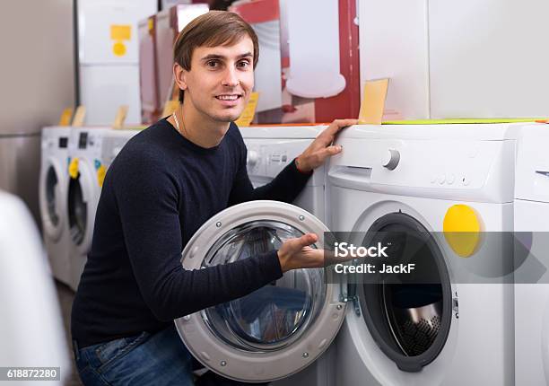 Man Choosing New Laundry Machine Stock Photo - Download Image Now - 25-29 Years, Adult, Agricultural Machinery