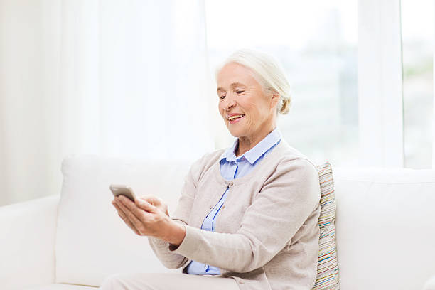 istock senior woman with smartphone texting at home 618873014