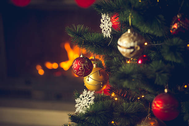 istock Red and golden baubles hanging on Christmas tree at fireplace 618873046