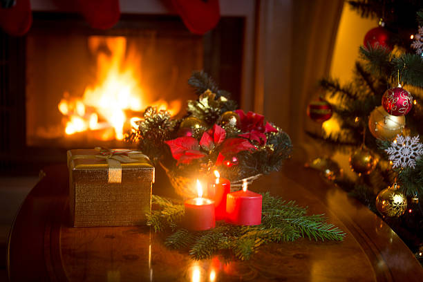 istock Christmas tree by the fireplace and golden gift box 618873350