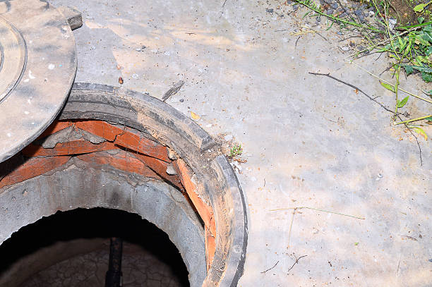istock Concrete cesspit with an open hatch on the ground 618873586