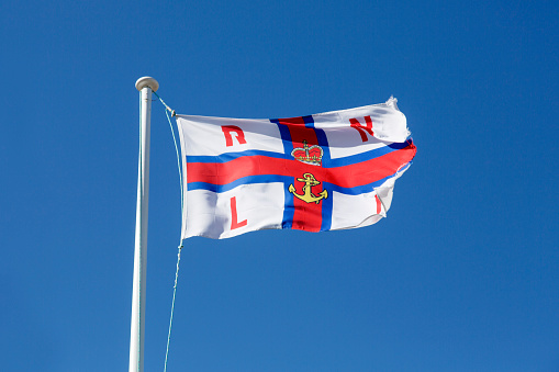 Port Isaac, Cornwall, UK: April 14, 2016: RNLI (Royal National Lifeboat Institution) flag flying outside the Port Isaac inshore lifeboat station. 