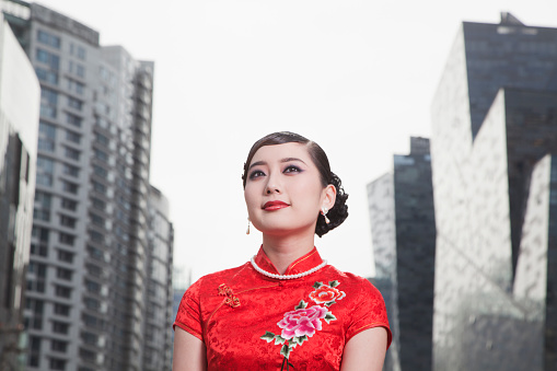 Chinese woman in traditional qipao dress in downtown city