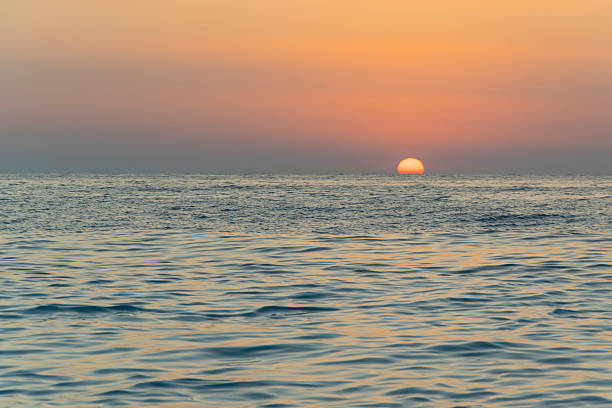 Romantic sunset on the sandy beach with blue sea waves 4 stock photo