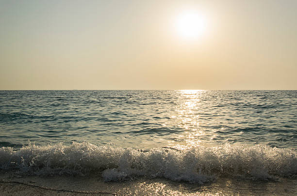 Sunset on the sandy beach with blue sea waves 4 stock photo