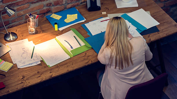 istock Young woman working late at a desk 618943494
