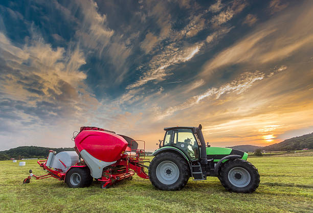 tracteur dans la lumière du coucher du soleil - provender photos et images de collection