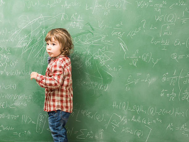 istock Little boy standing in front of green blackboard 618944066