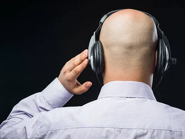 Photo of Bald headed man with headphone