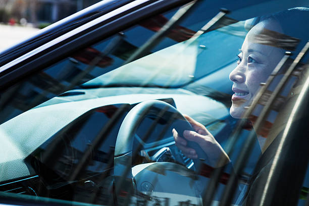 istock Woman driving car with flags reflection in windows 618946044