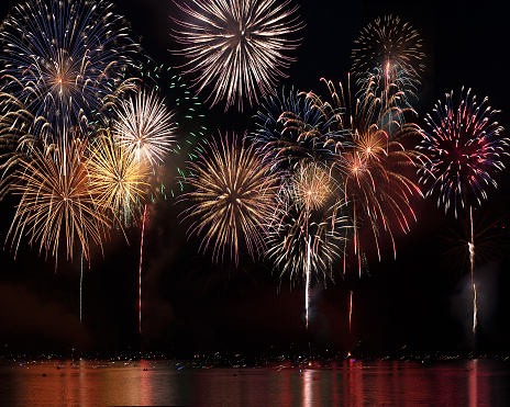 Brilliant display of fireworks over Donner Lake in Truckee, CA, with reflections on the water