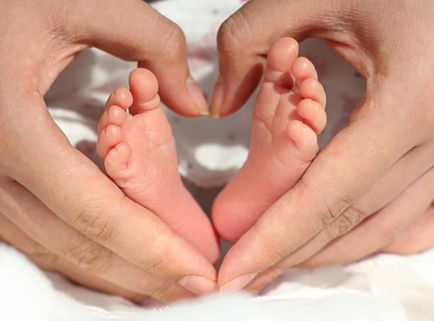 istock baby feet and mother hands 618950294