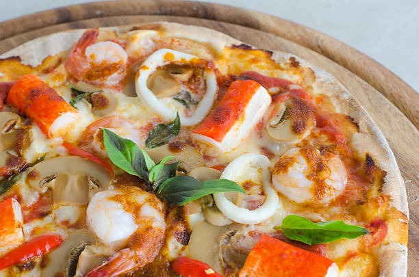 istock Seafood Italian Pizza slice on wood dish 618951786