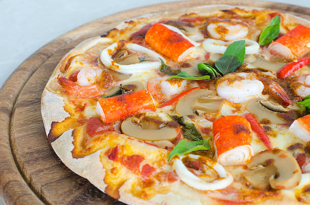 istock Seafood Italian Pizza slice on wood dish 618951788