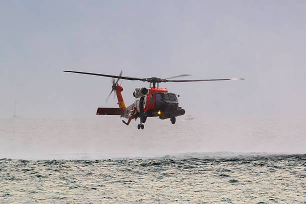 hubschrauber der küstenwache über dem ozean - rescue helicopter coast guard protection stock-fotos und bilder