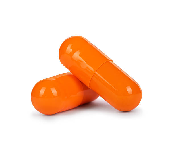 istock Close-up two yellow capsules isolated on white background 618959498