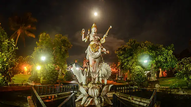 The Statue of Goddess Saraswati with Full Moon Background. Taken in Pura Giri Kusuma, one of the Balinese Hindu Temple in Sulawesi Indonesia.