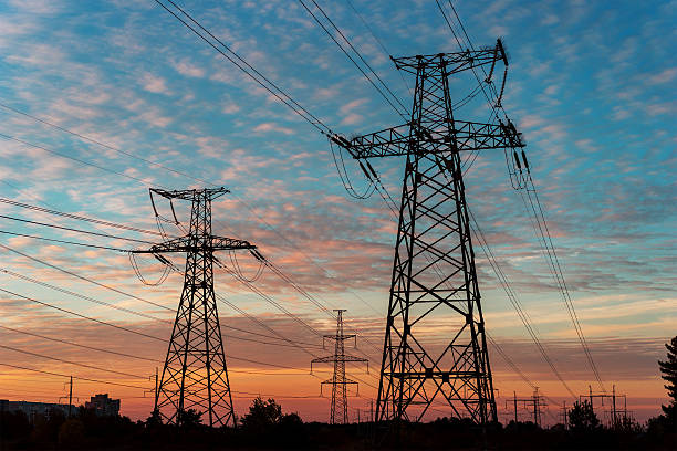 istock Electricity pylons and lines at dusk at sunset. 618963396