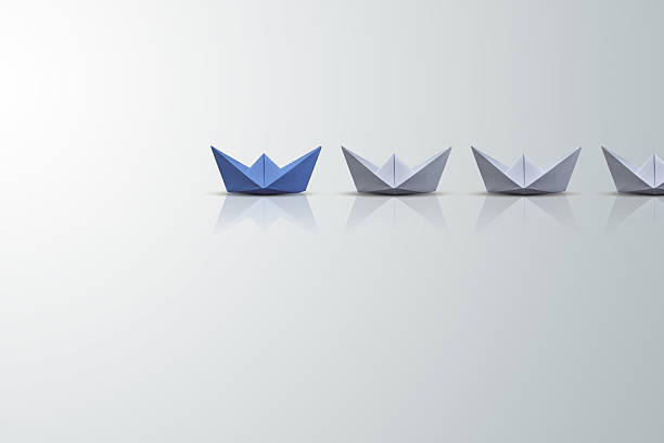 istock uniqueness concept, paper boat outstanding from the others 618964880
