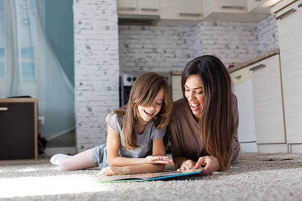 istock Cute mother and daughter reading book 618965416
