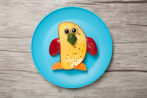 istock Penguin made of bread and cheese on plate and board 618966176