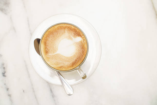 istock Top view coffee latte glass cup on white marble table 618966396