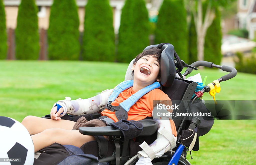 Behinderter Junge im Rollstuhl spielen mit Fußball im Park - Lizenzfrei Kind Stock-Foto