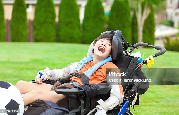 Behinderter Junge Im Rollstuhl Spielen Mit Fußball Im Park Stockfoto und mehr Bilder von Kind