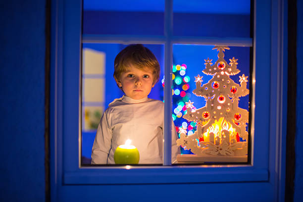 istock Little kid boy standing by window at Christmas eve 618969612