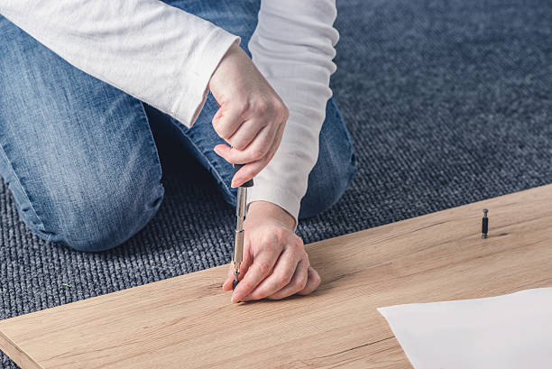 istock Woman assembling furniture at home, hand with screwdriver 618974322
