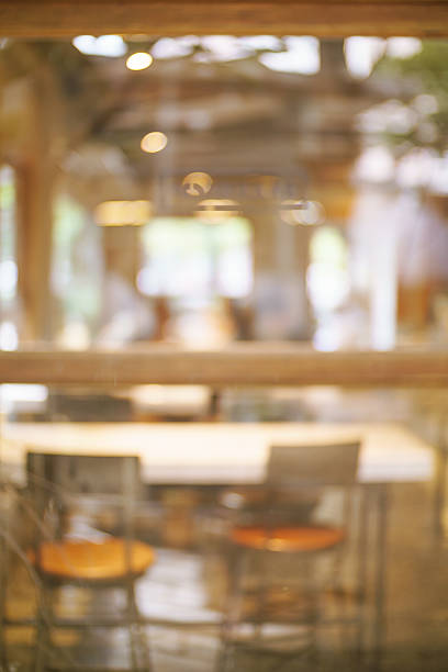 Blur cafe restaurant background shooting through glass window.