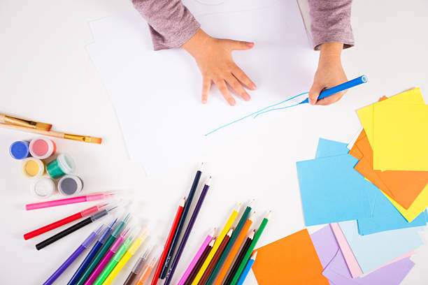 istock little girl drawing with colored pencils on paper 618975220