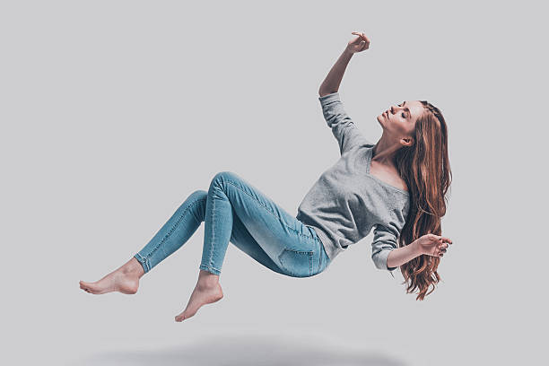 Hovering beauty. Full length studio shot of attractive young woman hovering in air and keeping eyes closed levitation stock pictures, royalty-free photos & images