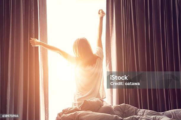 Mujer Que Se Estira Cerca De La Cama Después De Despertarse Foto de stock y más banco de imágenes de Despertar