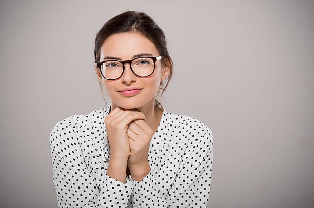 Fashion young woman Young woman wearing modern eyeglasses anf thinking isolated on grey background with copy space. Portrait of smiling fashion student wearing big glasses. Proud young businesswoman with spectacles looking at camera. nerd teenager stock pictures, royalty-free photos & images
