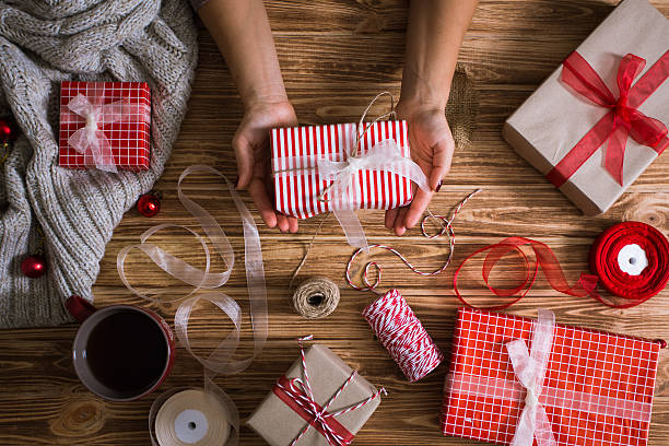 istock Female hands wrapping Christmas presents in paper 618976322