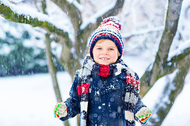istock Happy kid boy having fun with snow in winter 618976892