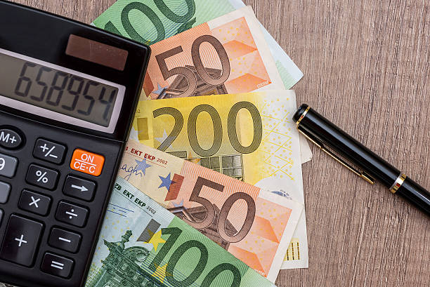 euro, calculadora y bolígrafo en el escritorio - currency euro symbol european union currency calculator fotografías e imágenes de stock