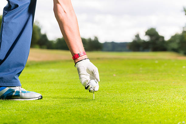 istock Man putting golf ball on tee, close shot 618979724