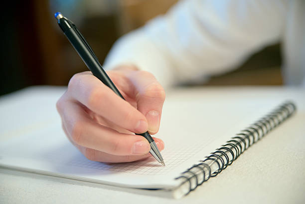 istock close up work woman writing on paper at her home 618979842