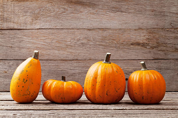 istock Autumn pumpkins on wooden board table 618981148