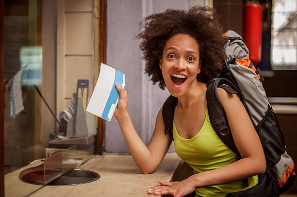 istock Euphoric backpacker female tourist shows ticket for her trip 618982032