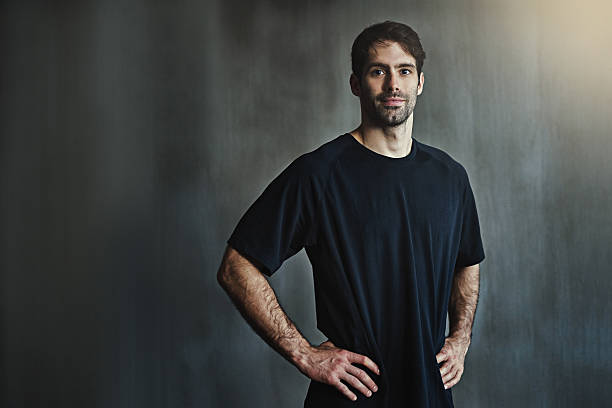 Portrait of a sporty young man posing against a gray background