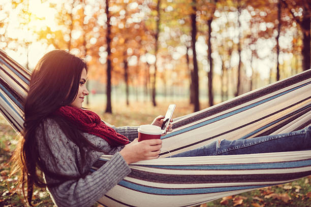 istock Young girl in hammock texting 619043628