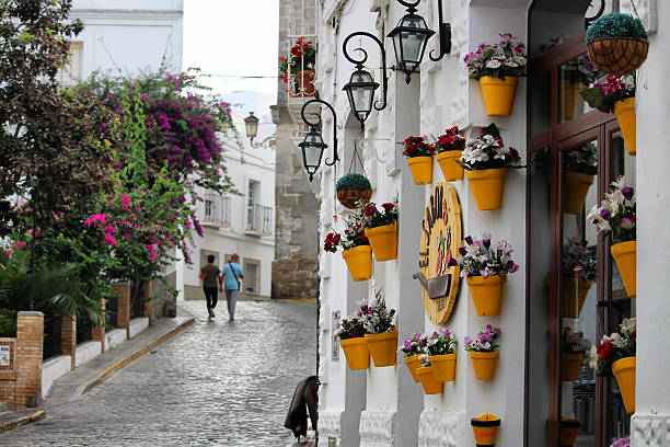 Pictoresque Tarifa at sunrise Cadiz/Spain - October 7, 2016 - People walking through a pictoresque street of the old town Tarifa at sunrise tarifa stock pictures, royalty-free photos & images