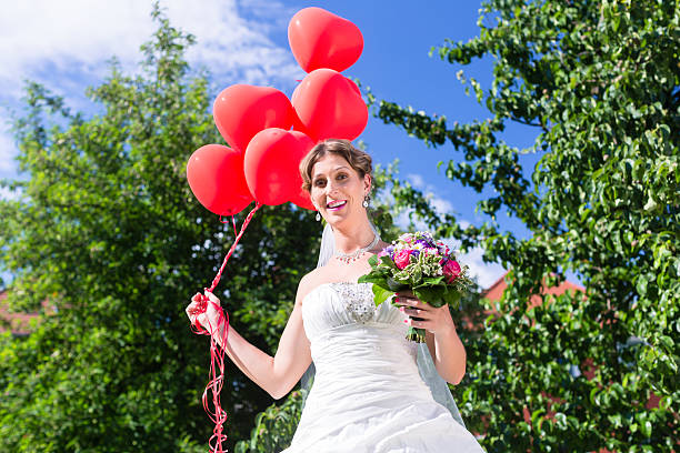 istock Bride at wedding with red helium balloons 619045134