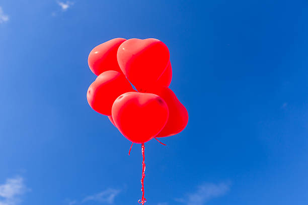 istock Red heart shaped helium balloons flying in the sky 619045196
