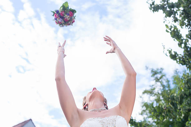istock Bride throwing flower bouquet at wedding 619045488
