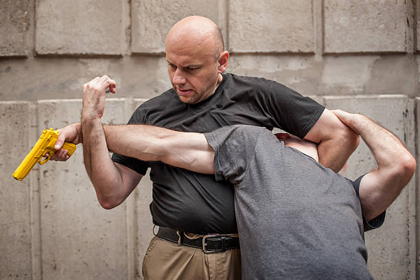 istock Gun Disarm. Self defense techniques against a gun point. 619045694